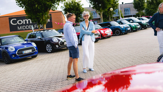 Kvinde og mand med MINI'er i baggrunden.