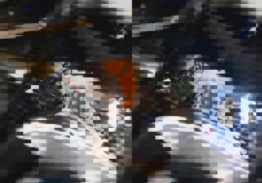 Et nærbillede af en mekaniker der lyser på en motorcykel.