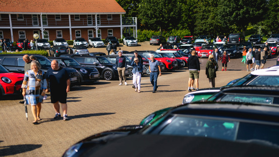 Parkeringsplads fyldt med MINI'er og mennesker.