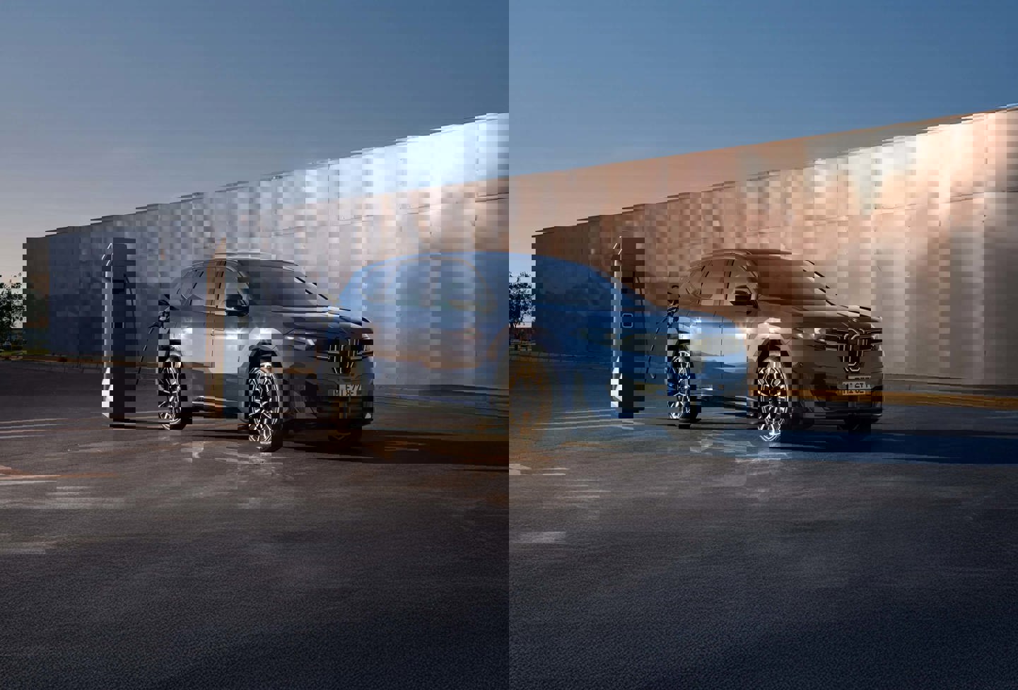 Et forvrænget billede af en sølvfarvet SUV parkeret på en vej med en stenet ørkenbaggrund under en klar himmel.