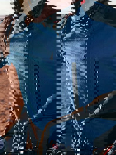 Et nærbillede af en person med BMW Motorrart jakke på i blå og sort. 