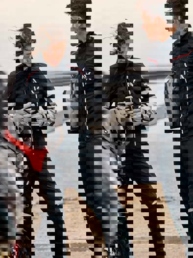 Mand og kvinde iført motorcykel-tøj, der står ved motorcykel