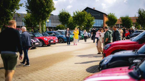 Fyldt parkeringsplads med mennesker og MINI'er.