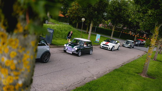 En række MINI'er kører i kortege.