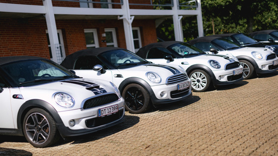 Række af hvide MINI'er med fartstriber parkeret.