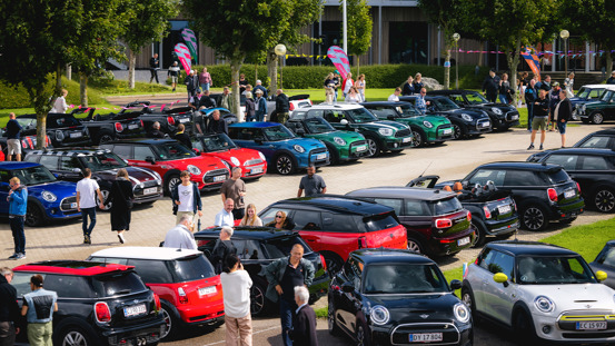 Fyldt parkeringsplads med MINI'er og mennesker.
