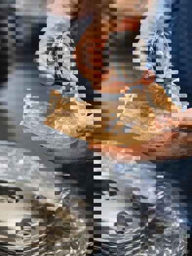 En person holder en reservedel.