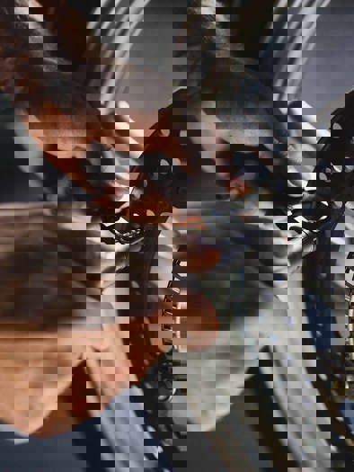 To hænder udfører service på hjulet på en BMW Motorrad Motorcykel.