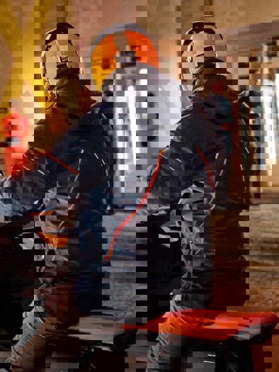 En person holder parkeret på motorcykel foran et event inde i en bygning.